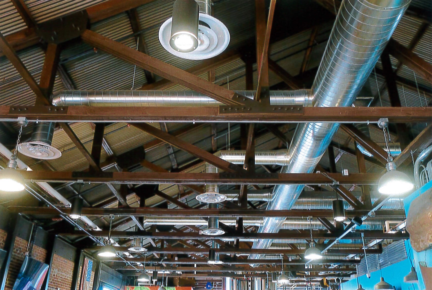 View of restored roof trusses, new corrugated metal roofing